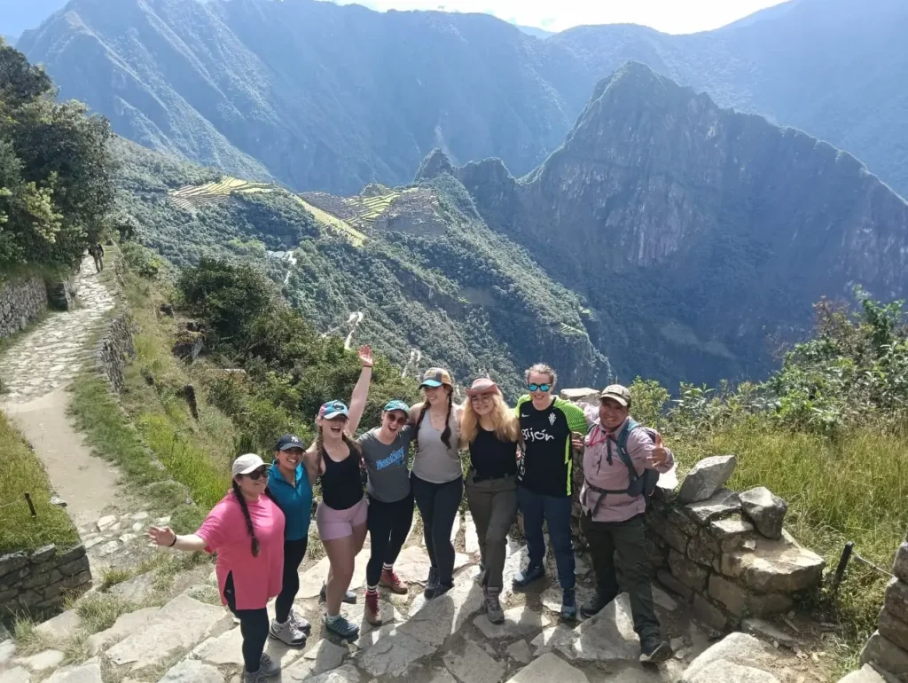 Trekkers arriving at the Sun Gate with Machu Picchu visible in the valley below
