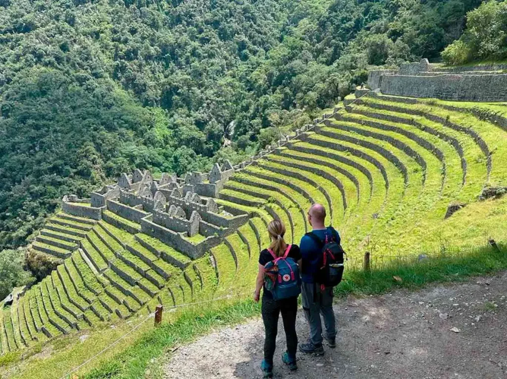 Two trekkers admiring Wiñay Wayna terraces on the Short Inca Trail before the Sun Gate